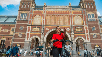 A group on an Amsterdam e-bike tours at the entrance of the Rijksmuseum – the national museum of Amsterdam.