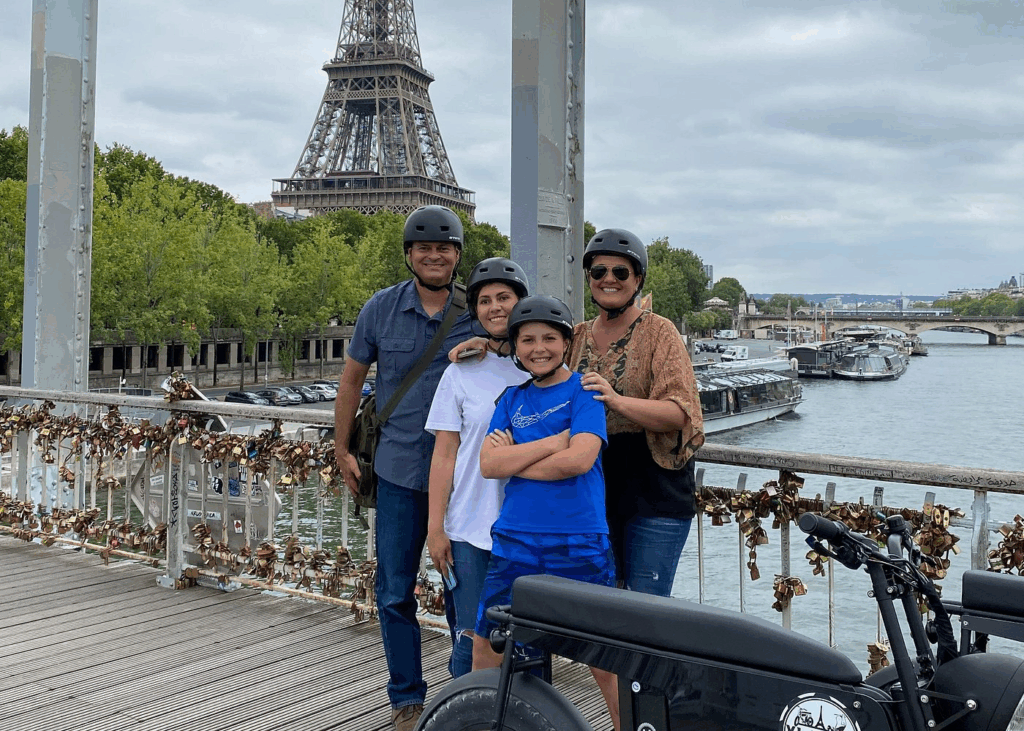 Pont des Arts pedestrian bridge with Eiffel Tower and a family enjoying a Paris bike tours for families