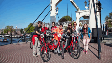 Group of riders with rental bikes on bridge of canal during bike rental Amsterdam