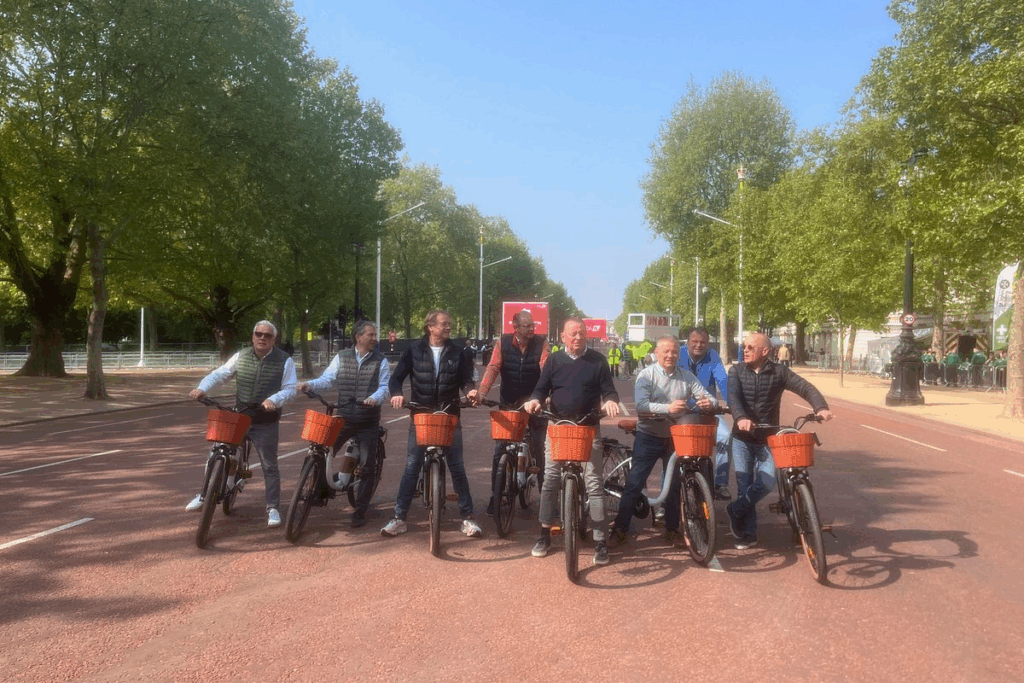 A group of men on bicycles with baskets having a good time on a London Bike Tour
