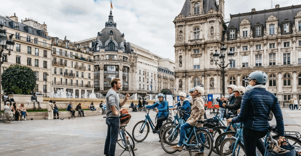 A  group of cyclists listening to their tour guide on a Paris Bike Tour