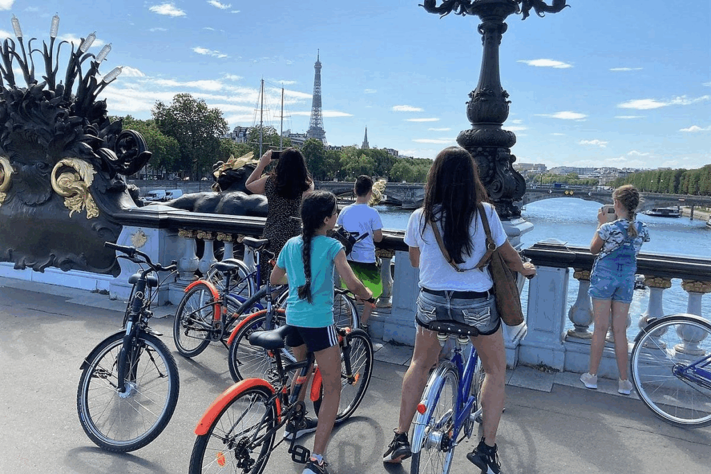 A family enjoying a bike tour on a bridge over the River Seine on a Paris Bike Tours for Families