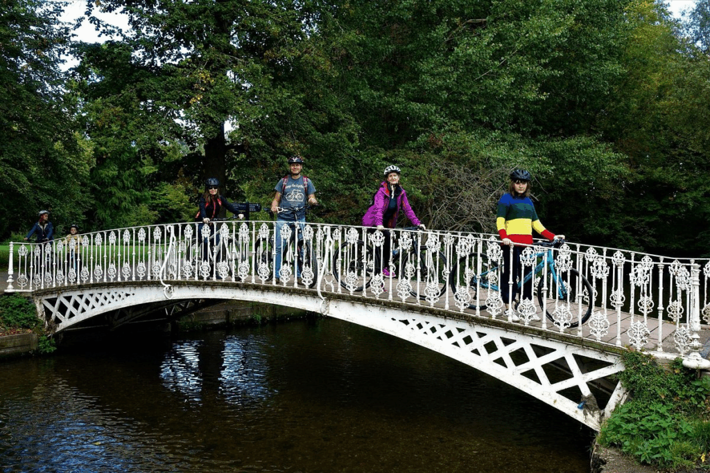 A family group on bikes on an old wrought iron bridge on a London private tours activity