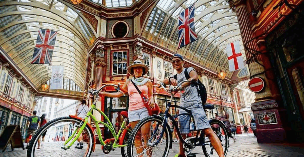 A couple on bikes in an old time London arcade on a London private tours activity